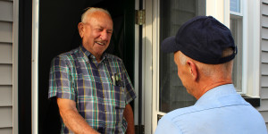 Reader Heating and Cooling technician greeting homeowner at the door during an HVAC service call.